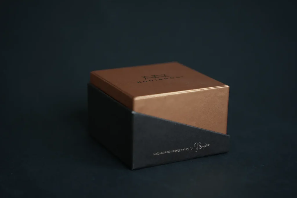 Nodi & Hue luxury jewelry gift box with bronze lid on dark background